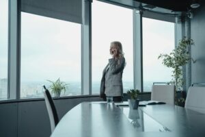 woman in gray coat standing near glass window