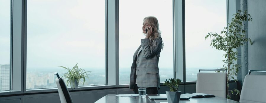 woman in gray coat standing near glass window